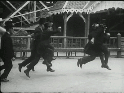 A scene from Entr’acte, showing edwardian men skipping in a circle