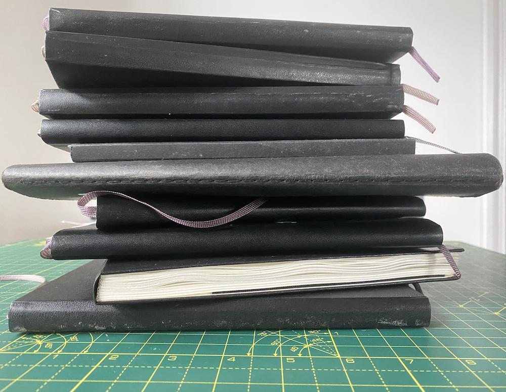 A pile of Adam Westbrook’s finished sketchbooks
